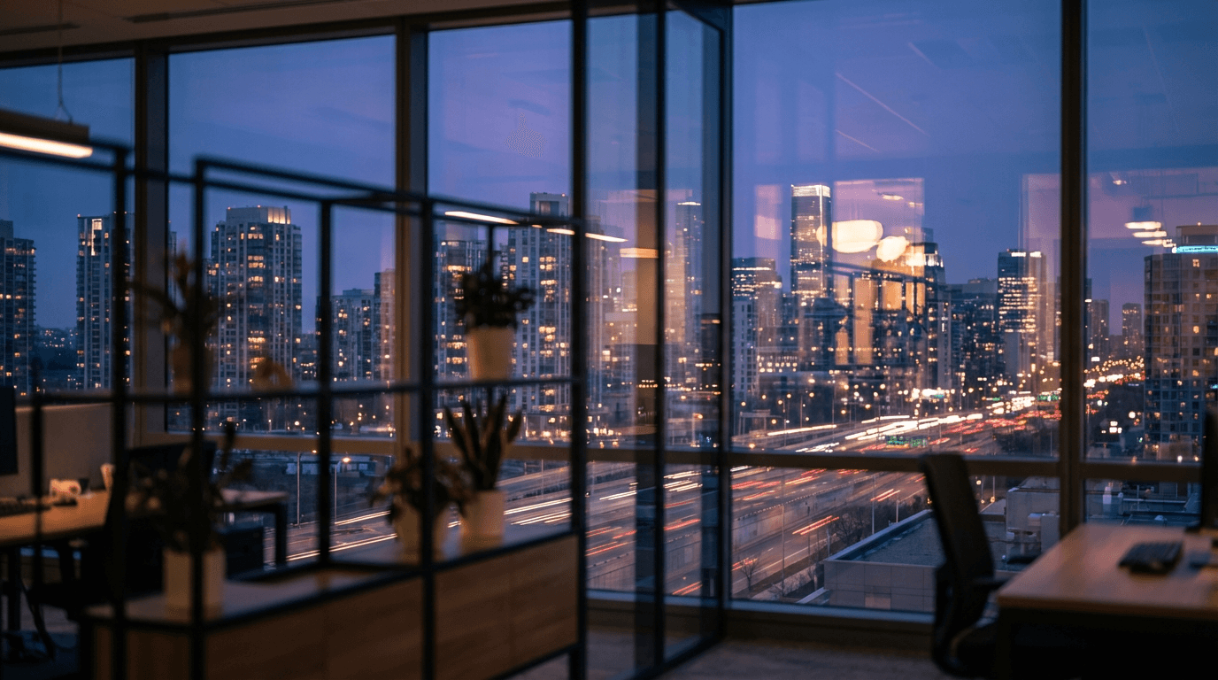 Twilight view of a glass-and-steel downtown office tower with warm lobby lighting, wet sidewalks, and a quiet commercial street, premium architectural photography, charcoal and gold tones